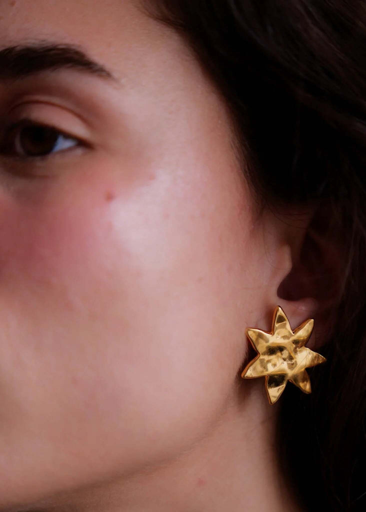 Raisa Earrings — Gold starburst stud earring on model, detail — MYFASHIONFRUIT