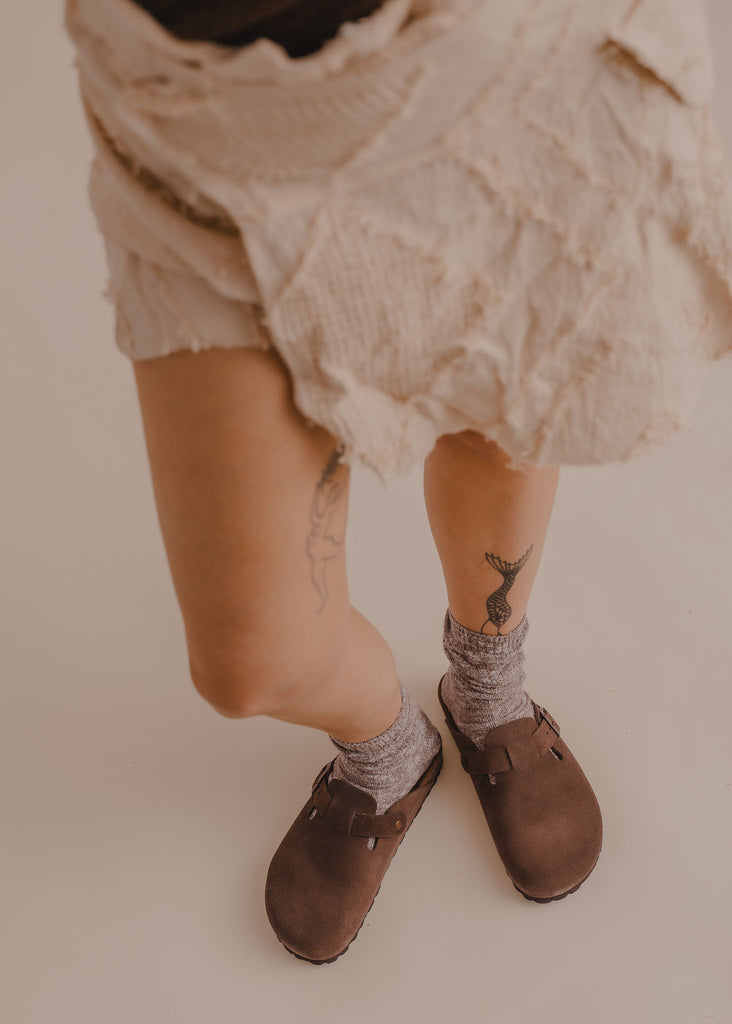 Bilbao Suede Clogs — Brown suede shoes, grey socks, white skirt, on model — MYFASHIONFRUIT
