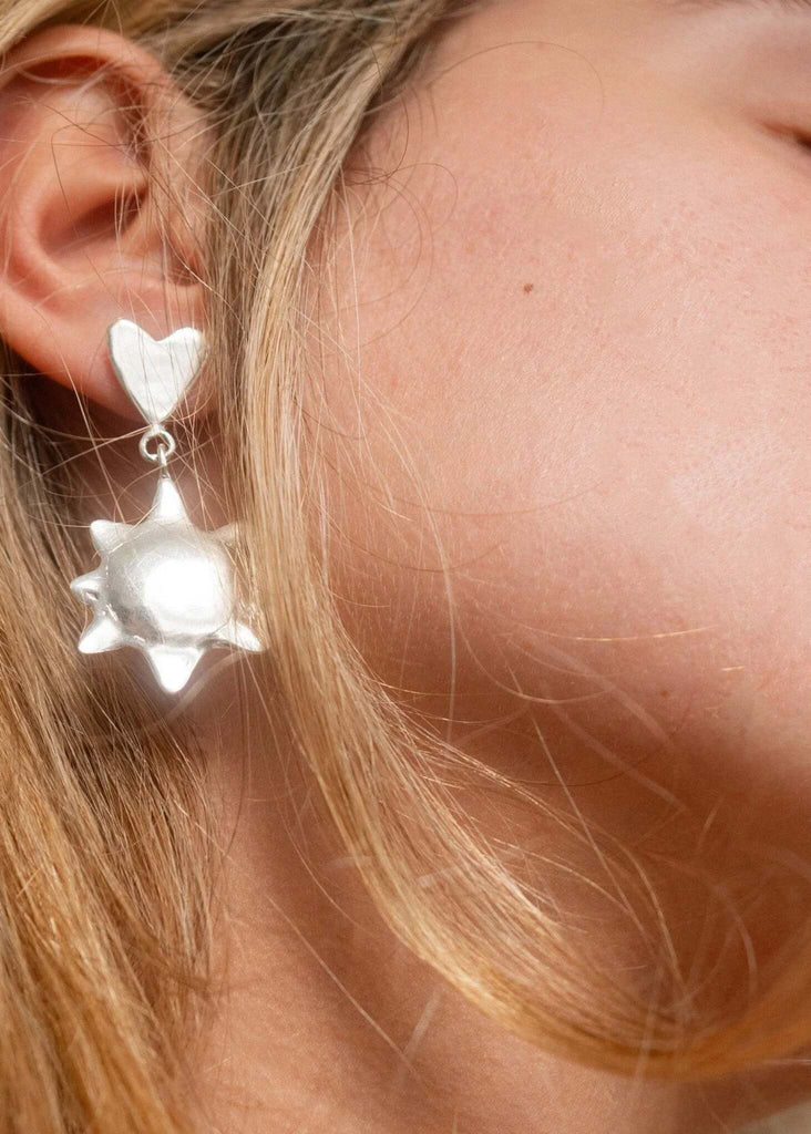 Alectrona Earrings — Silver heart and sun earrings on model — MYFASHIONFRUIT
