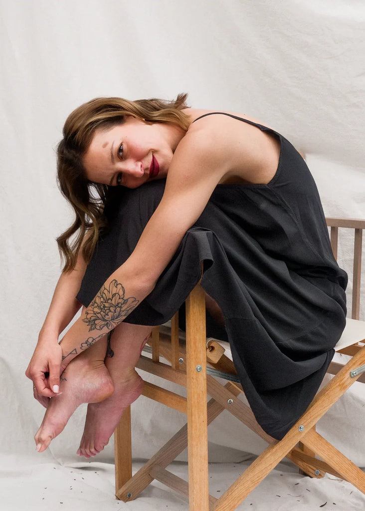 Granadas Dress — Black slip dress on model sitting on chair — MYFASHIONFRUIT