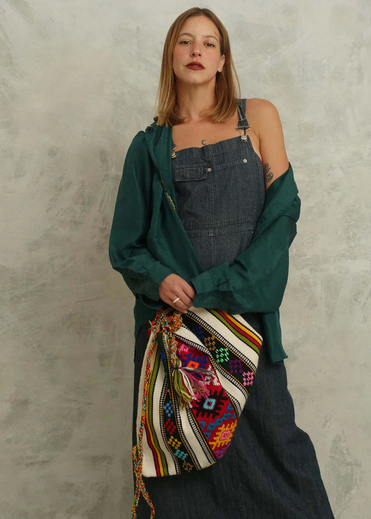 Woman wearing denim overalls with Roxane Handloom Bag, colorful geometric pattern — MYFASHIONFRUIT