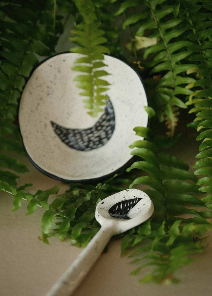 The Moon Spoon — white ceramic with moon detail, among green leaves — MYFASHIONFRUIT